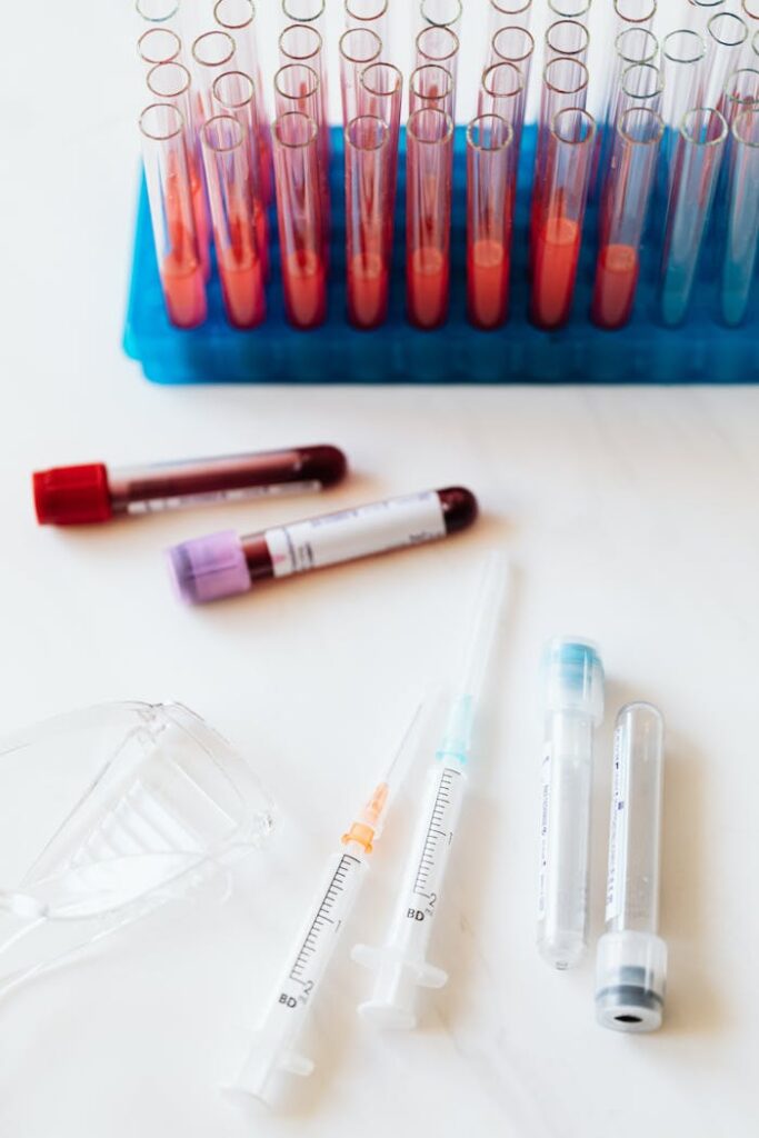 pexels-photo-4226894 From above of transparent test tubes with colorful liquids placed on blue stand and table near syringes and plastic eyeglasses